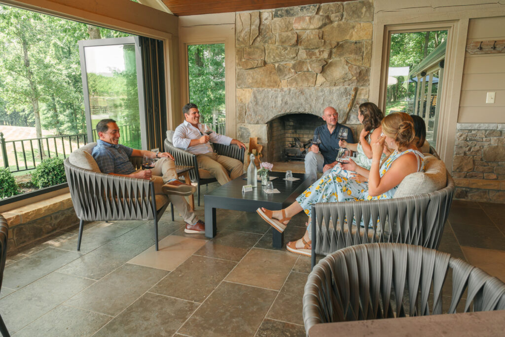 A group of people gathered around a table with a stone fireplace in the background