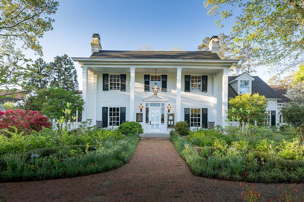 Front view of large Inn with garden on both sides.